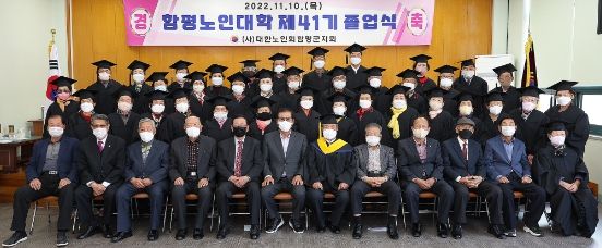 이상익 군수와 졸업생들이 기념사진을 찍고 있다