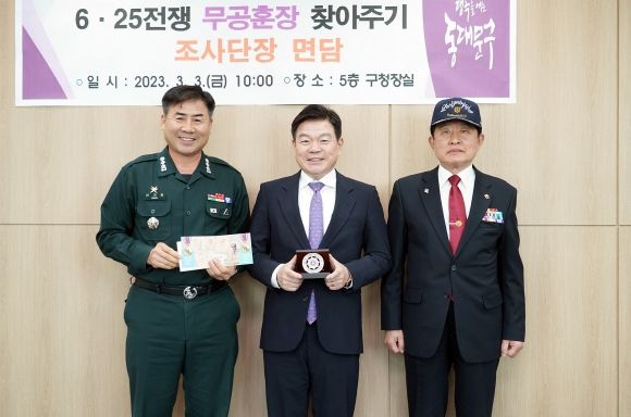 이필형 동대문구청장(사진 가운데)이 신기진 육군본부 조사단장(사진 왼쪽), 하창식 무공수훈자회 동대문구지회장(사진 오른쪽)과 기념 촬영을 하고 있다.