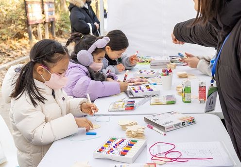 18일 강서구민회관 일대에서 열린 ‘아동권리주간 기념행사’에 참석한 아이들이 나무목걸이 만들기 체험을 하고 있다.
