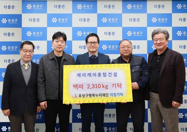 27일 제이케이종합건설에서 백미를 기탁하고 기념촬영을 하고 있다. / 왼쪽부터 홍정환 유성구 행복누리재단 상임이사, 이경희 전무이사, 조부영 대표, 최영호 현장소장, 정용래 유성구청장
